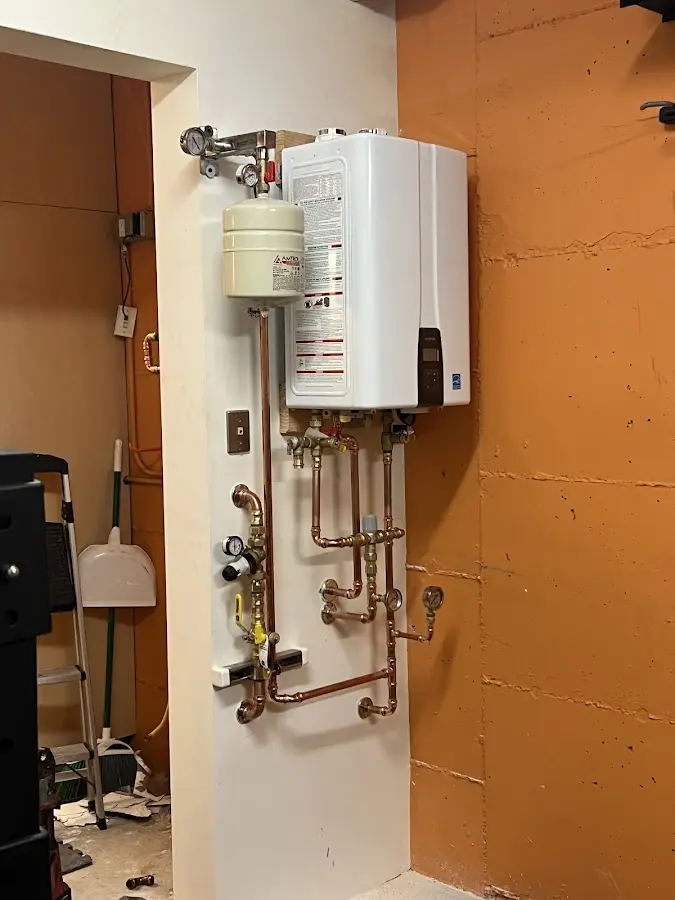 Plumbing technician inspecting water heater connections in Edgefield